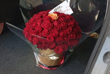 A bouquet of red roses with a card, left in a vehicle